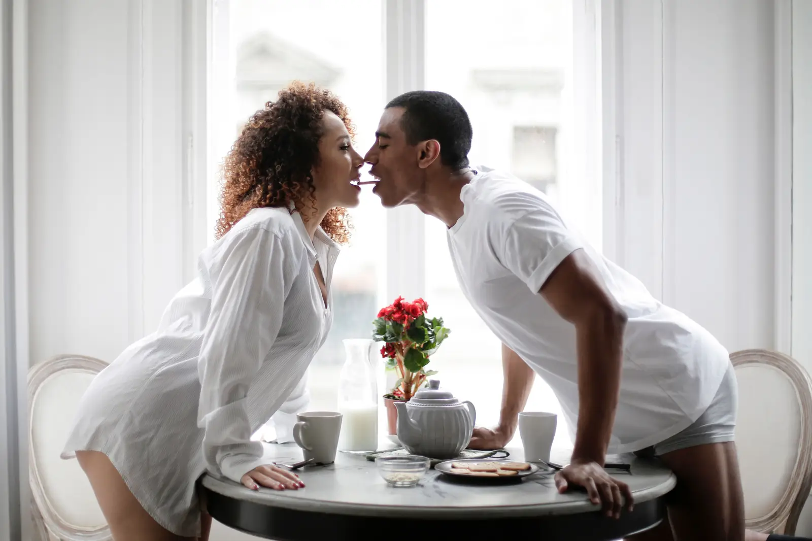 Pareja sonriendo con complicidad, imagen ilustrativa de stock, no representa a miembros reales