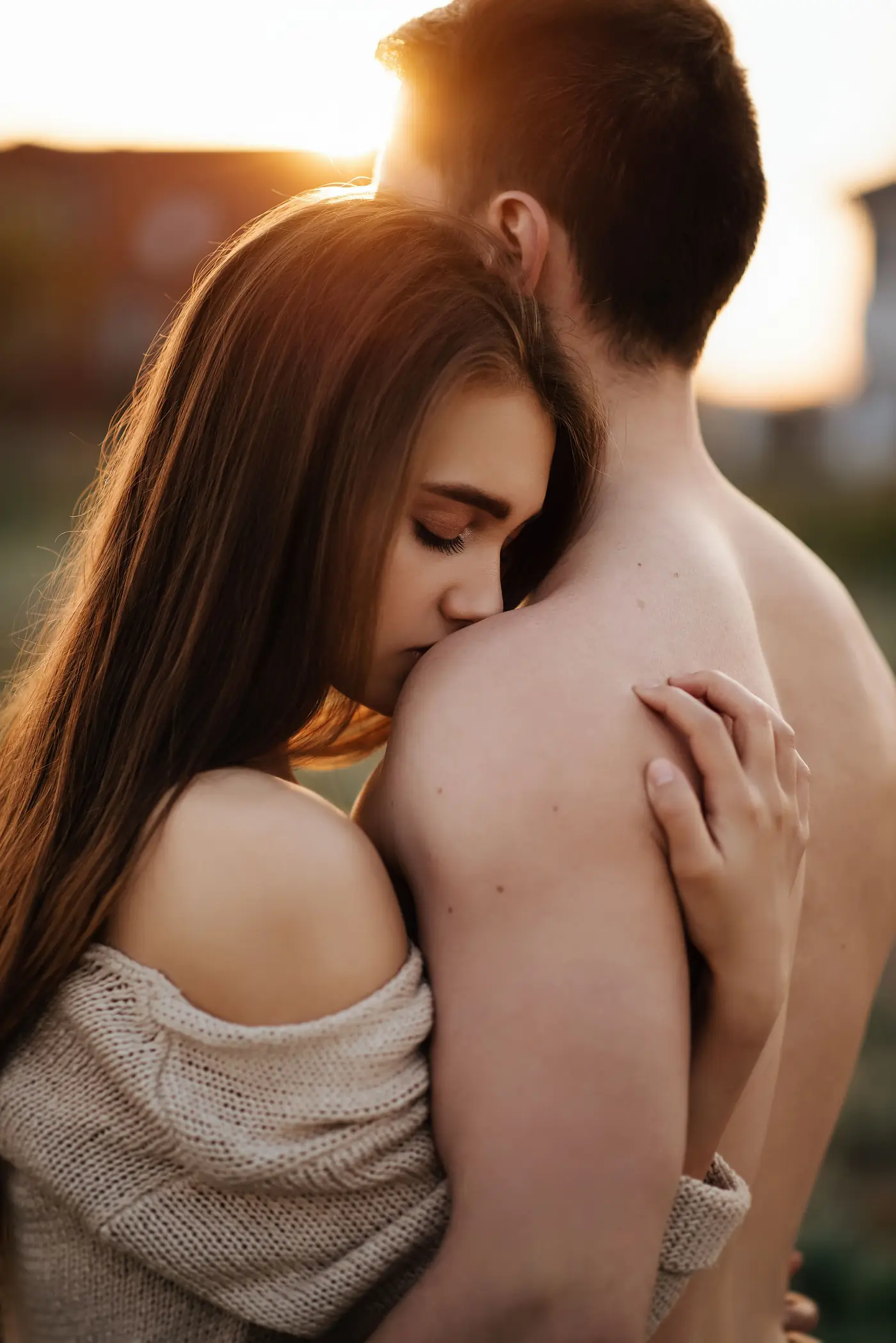 Pareja abrazada con cariño al atardecer, imagen ilustrativa de stock, no representa a miembros reales